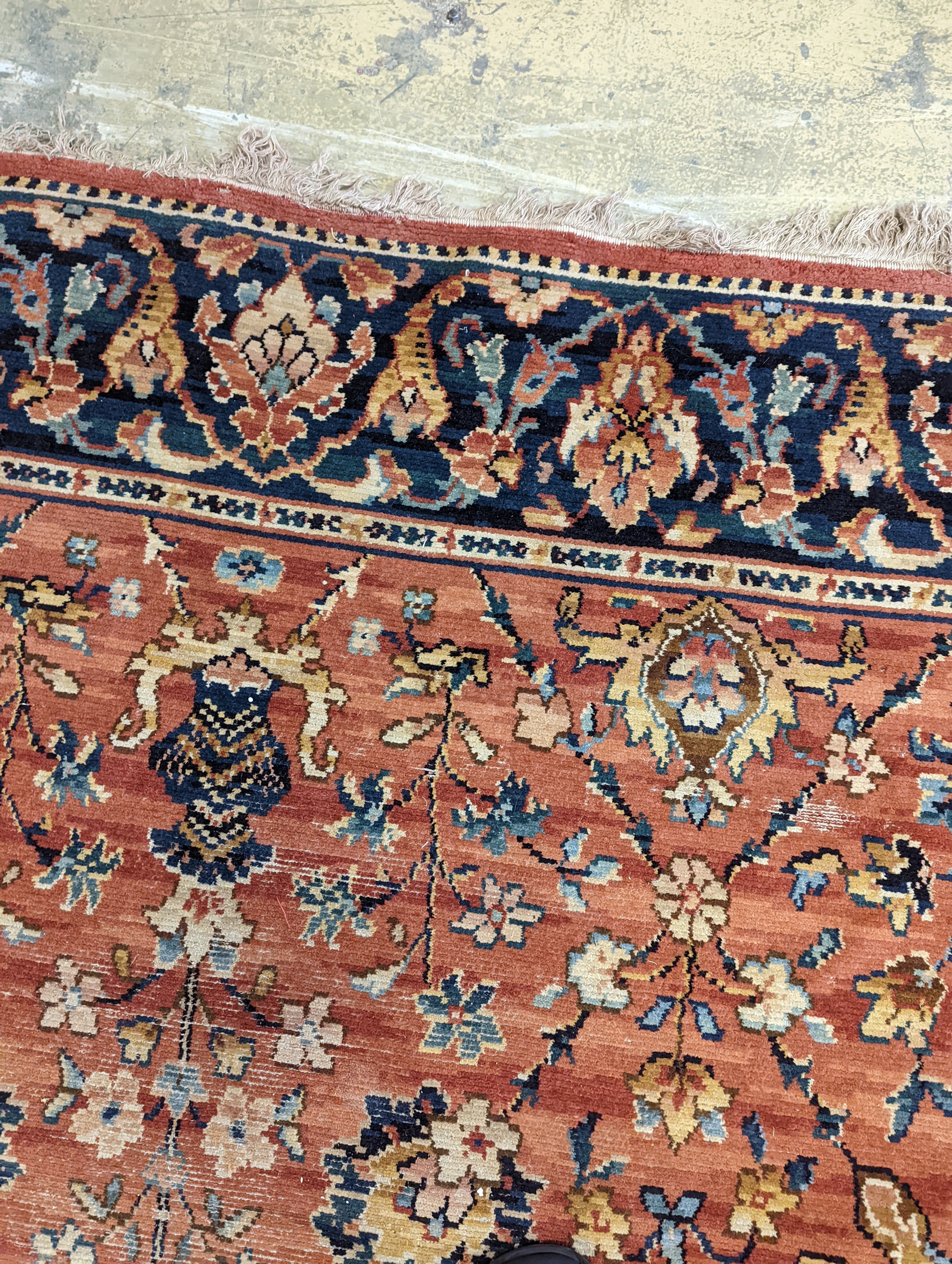 A Persian style machined brick red ground carpet (severely worn), 392 x 286cm